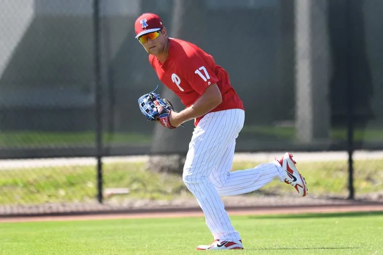 Rhys Hoskins chases down a ball in the outfield during spring training workouts.