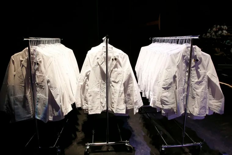 White coats were hung before a ceremony for new students at the University of Pennsylvania Perelman School of Medicine in 2015.  YONG KIM / Staff Photographer