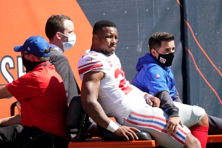 New York Giants running back Saquon Barkley (26) is carted to the locker room after being injured.