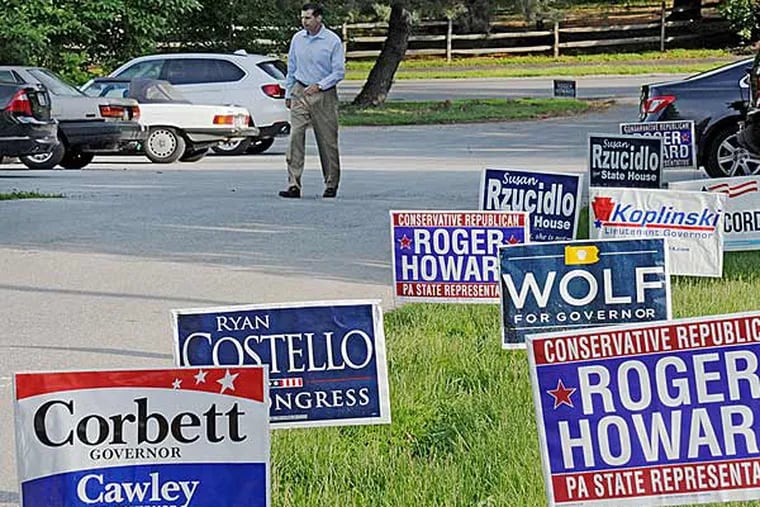 Campaign posters greet a voter heading to East Bradford South precinct No. 1 at the Chester County Art Center on Primary Day in Pennsylvania.