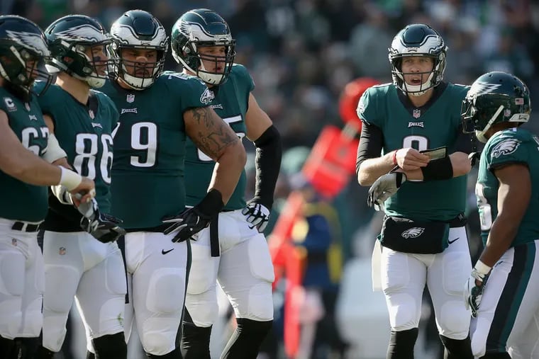 Nick Foles (second from right) talks with his teammates during Sunday's game.