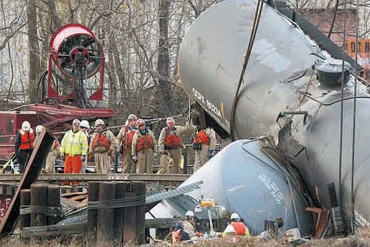 Work crews prepare to hoist the derailed tanker cars from the Mantua Creek in Paulsboro NJ. on the afternoon of Tuesday December 12th. A large crane was brought in to lift the emptied cars.( Ed Hille / Staff Photographer )