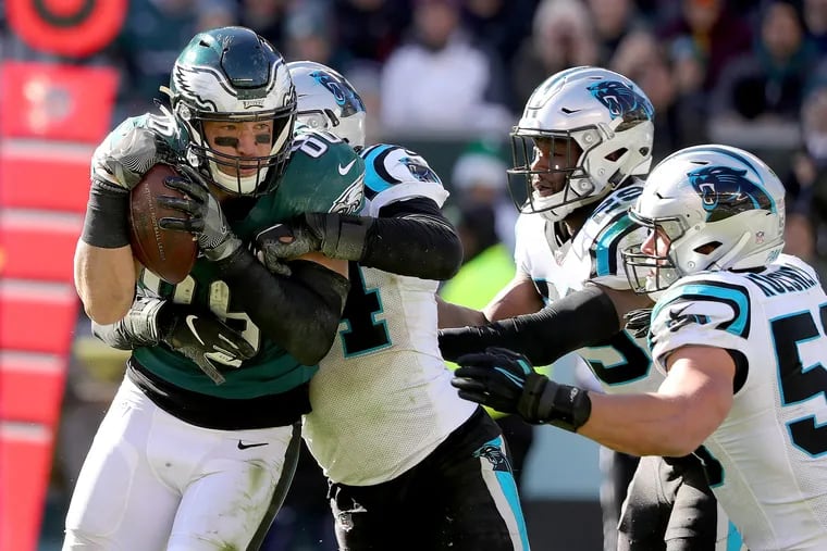 Zach Ertz (left) is hit by Shaq Thompson as he catches a pass on Sunday.