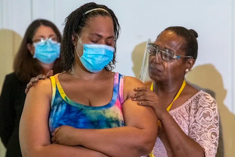 The Rev. Andrea Harrington (right) consoles Crystal Davis, sister of a murdered transgender woman, during a news conference about recent developments in homicide cases involving the deaths of two transgender women in Philadelphia.
