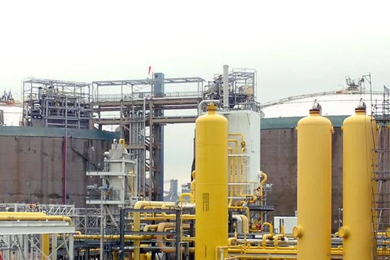 The PGW plant on Venango St. in Port Richmond. The two tall storage tanks in the background hold the liquified natural gas at a temperature of minus 260 degrees. The walls of the storage tank are approximately 15 feet thick.  The four yellow towers in the foreground are "the expanders' where the natural gas (vapor form) is purefied of extraneous elements before being liquified. ( Clem Murray / Staff Photographer )
