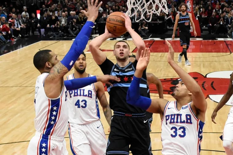 Bulls guard Zach LaVine (center) goes to the basket as the Sixers' Jonah Bolden (43) and Tobias Harris (33) defend.