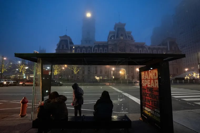 People at a bus stop in front of City Hall in the morning, in Philadelphia, March 20, 2020. The coronavirus continues to spread in Pennsylvania and across the United States. In Pennsylvania, all businesses that aren’t "life-sustaining" closed the night before at 8 p.m.