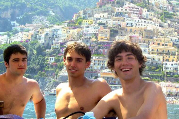 Brian Remondino (right) and friends Dan Sholder (left) and John Ripple on the boat ride to go cliff jumping - and a grand view of a hillside of colored houses in Positano (BRIAN REMONDINO / For the Inquirer).