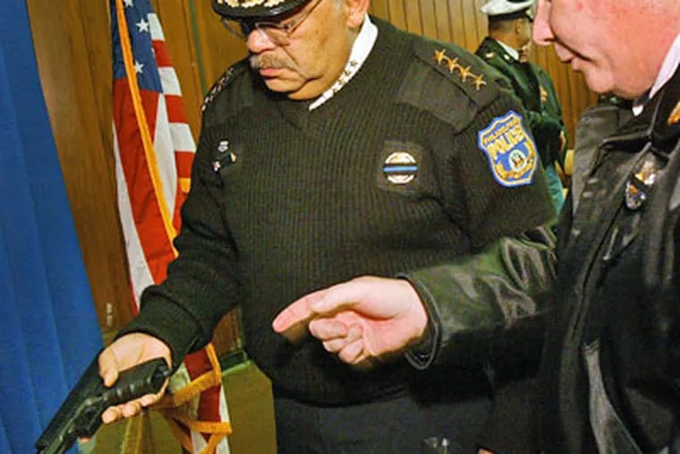 Philadelphia Police Commissioner Charles Ramsey, (left) handles a Glock semi-automatic pistol during a press conference Friday. (Alejandro A. Alvarez / Staff Photographer)