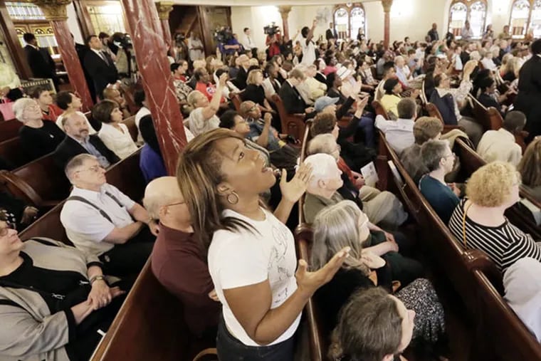 Monet Amos of Philadelphia sings during a prayer vigil at Mother Bethel AME Church on June 18, 2015. ( ELIZABETH ROBERTSON/Staff Photographer)
