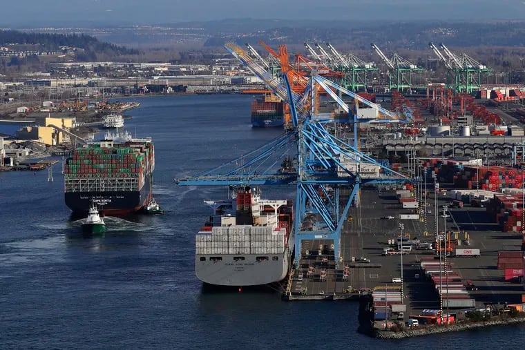FILE photo shows Cape Kortia container ship, left, heading into the Port of Tacoma in Commencement Bay in Tacoma, Wash. (AP Photo/Ted S. Warren, File)