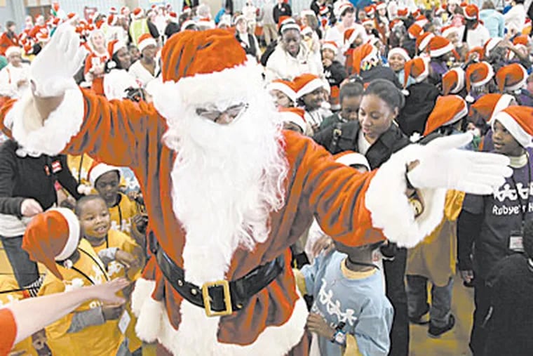 Santa Claus greets children during a Christmas party for children from North Philadelphia at Girard College on Saturday afternoon. (Laurence Kesterson / Staff Photographer)