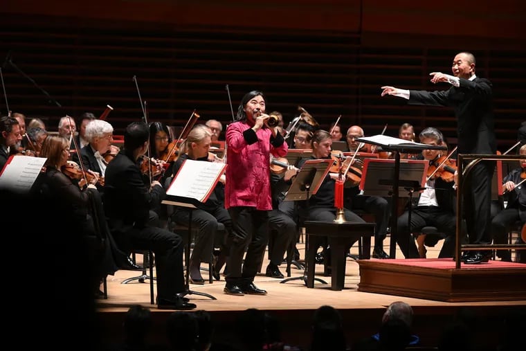 Guest conductor Tan Dun (right) with suona soloist Guo Yazhi (center, in red), playing suona, at the Philadelphia Orchestra's China Night Saturday at the Kimmel Center.
