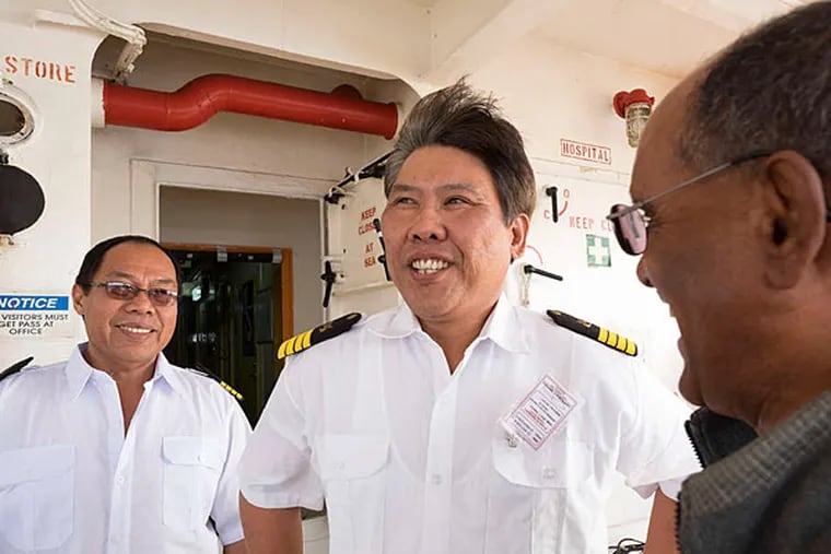 Capt. Eric Pabelico (center) of the cargo ship Nicolina, formerly the Nikol H, with a crew member and Mesfin Ghebrewoldi (right) of the Seaman's Church Institute. The ship, with new crew and new owners, is registered in the Philippines.