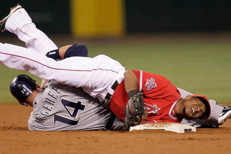 Erick Aybar of the hard-luck Angels grimaces after the Brewers' Casey McGehee slides into him to break up a double play.