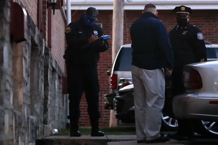 Philadelphia Police investigators stand outside the Michner Court Apartments in Northeast Philadelphia after the shootings Friday. A maintenance worker found a male and female with gun shots to the head.
