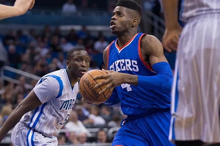 Philadelphia 76ers center Nerlens Noel (4) drives to the basket as Orlando Magic guard Victor Oladipo (5) defends during the first half of an NBA basketball game in Orlando, Fla, Sunday, Feb. 22, 2015. (Willie J. Allen Jr./AP)