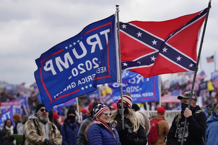 Trump supporters Candria Crisp, center, and Cynthia Crisp, back center, talk with another trump supporter holding a confederate flag at a Trump Rally at the ellipse in Washington, D.C. on January 6, 2021.