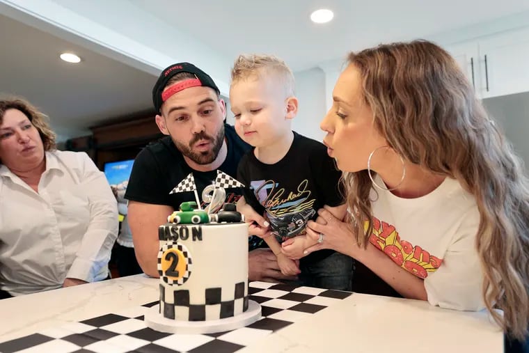 Charles Sigwart and Amanda Sigwart (right) help their son Mason Sigwart blow out the candle on his birthday cake during Mason’s second birthday party at the Sigwart family home in Marlton, N.J., on March 26.