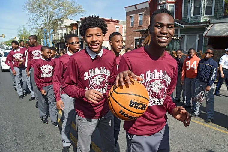 Ahzayar Eillis (right) and Isaiah Collins join their teammates in marching on Lehigh Avenue.