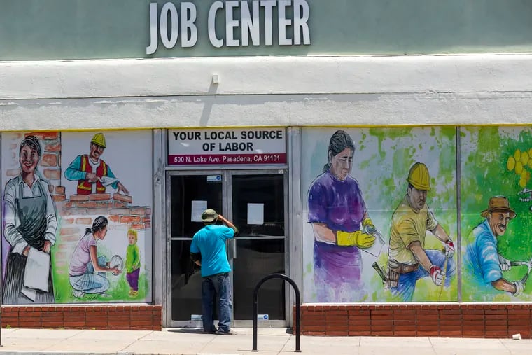 A person looks inside the closed doors of the Pasadena Community Job Center in Pasadena, Calif., during the coronavirus outbreak, in May 2020.