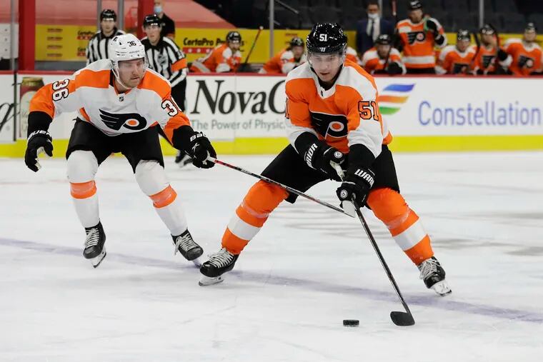Flyers defenseman Derrick Pouliot skates with the puck against right winger Linus Sandin during an intrasquad game Jan. 10 at the Wells Fargo Center.