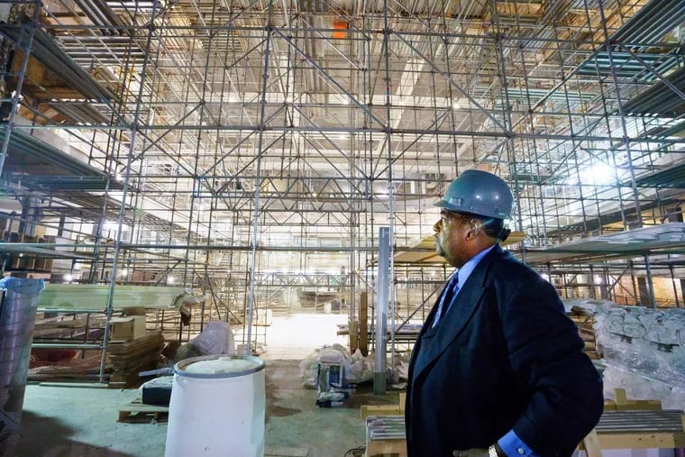The Rev. Mark Hatcher, pastor of Holy Ghost Headquarters, stands inside the Met Philadelphia, a former opera house being renovated in Francisville. The church owned the 110-year old building before selling it to a developer, who is turning the venue into a concert hall where the church will continue to hold services.