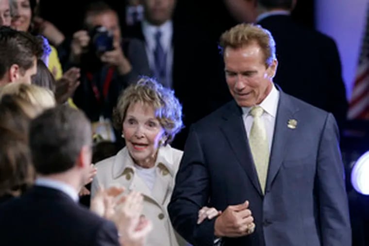 California Gov. Arnold Schwarzenegger escorts Nancy Reagan to her seat at her husband&#0039;s presidential library in Simi Valley.