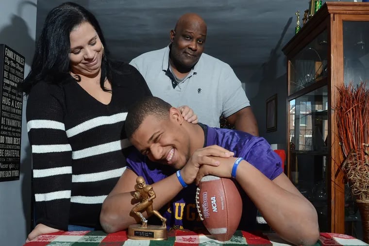 Ojay Harris (center) smiles with his parents, Dawn Harris and Shannon Harris.