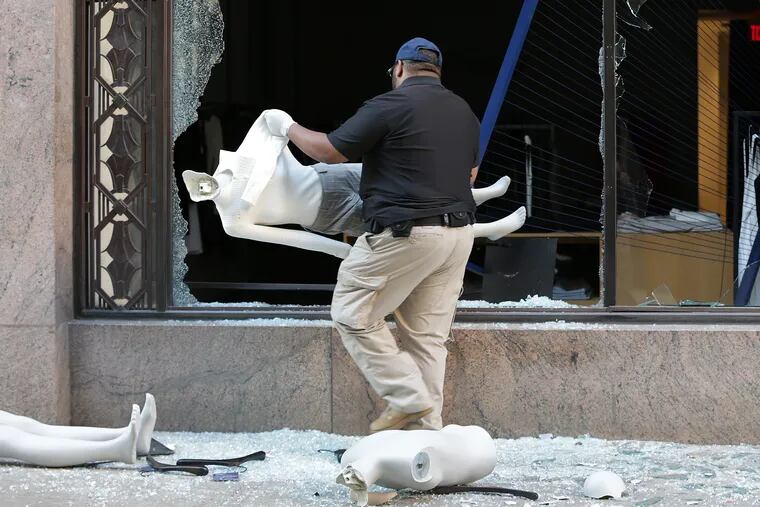 An unidentified security guard cleans up outside the Theory shop.