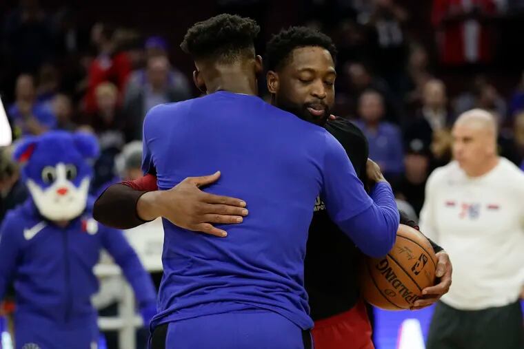 Miami Heat guard Dwyane Wade hugs Sixers guard Jimmy Butler during pregame warm-ups on Thursday, February 21, 2019 in Philadelphia.