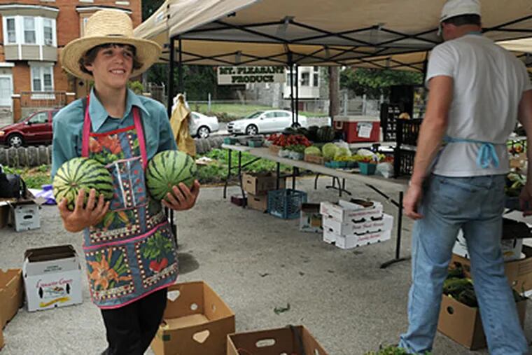 At a Hunting Park farmers' market, John Stoltzfus, 17, carries melons. (April
Saul / Staff Photographer)