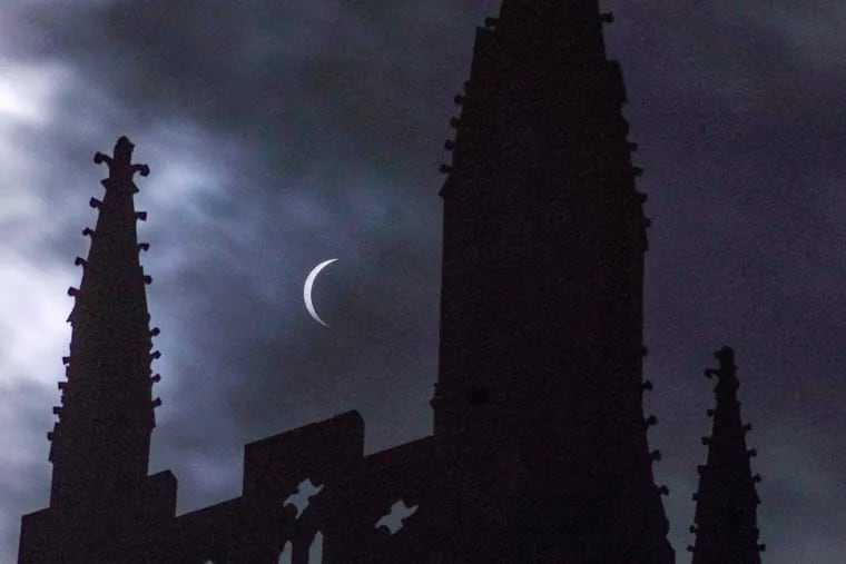 The partial eclipse is framed by the spires of the Bryn Athyn Cathedral, in Bryn Athyn, Montgomery County, on Monday.
