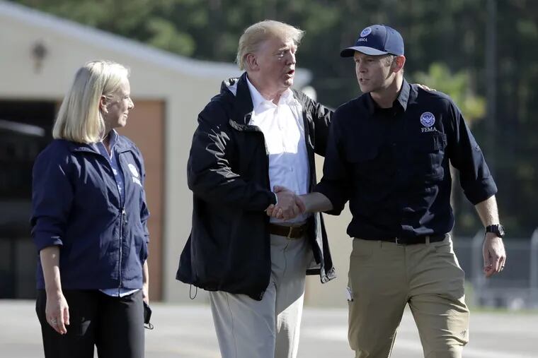 President Trump shakes hands with FEMA Administrator Brock Long as Homeland Security Secretary Kirstjen Nielsen watches after visiting areas in North Carolina and South Carolina impacted by Hurricane Florence, Wednesday, Sept. 19, 2018, at Myrtle Beach International Airport in Myrtle Beach, S.C.