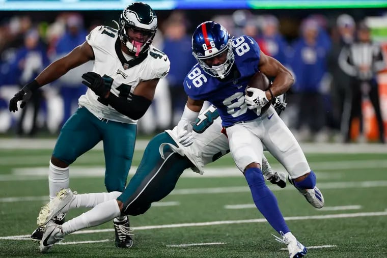 New York Giants wide receiver Dennis Houston runs by Eagles cornerback Bradley Roby and Eagles linebacker Nicholas Morrow in the third quarter.