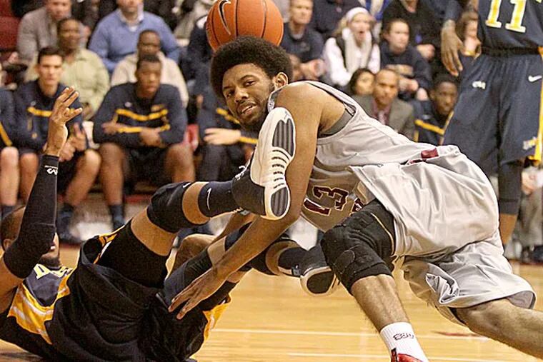 Drexel's Chris Fouch and Saint Joseph's DeAndre' Bembry fall to the ground after getting tangled up during the first half. (Charles Fox/Staff Photographer)