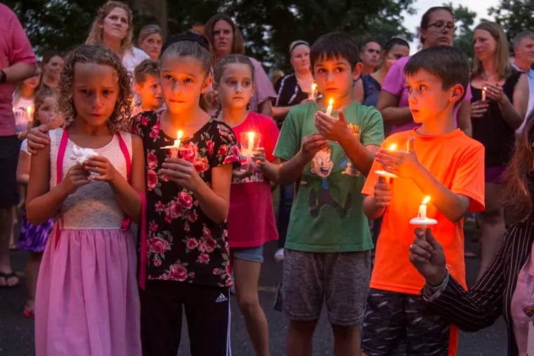 Classmates of Kayden Mancuso, the seven-year-old girl who was killed by her father in Manayunk hold candles at the end of a vigil for her at their school, Edgewood Elementary School, in Yardley on Tuesday night.