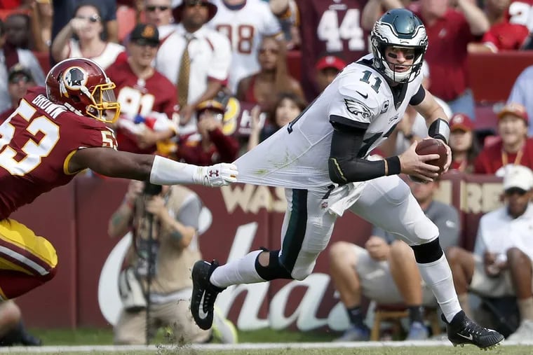 Carson Wentz (right) managed to throw two touchdowns, despite inconsistent pass protection.