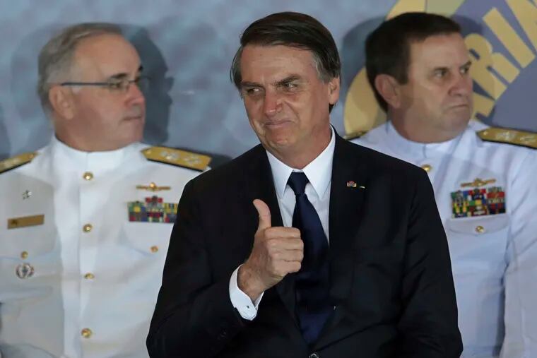Brazil's President Jair Bolsonaro gives a thumbs up during the inauguration ceremony of the new naval commander, Ilques Barbosa Junior, at the Naval Club in Brasilia, Brazil, Wednesday, Jan. 9, 2019. (AP Photo/Eraldo Peres)