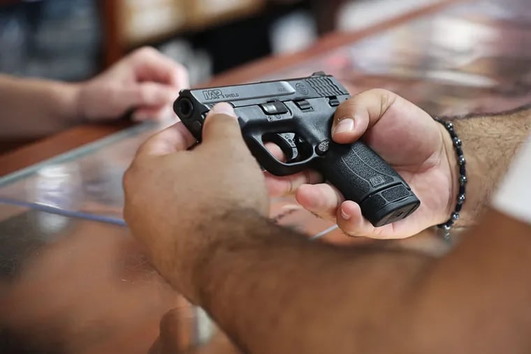 A customer looks at a handgun in a Kissimmee, Fla., gun store.