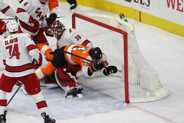 Travis Konecny (11) of the Flyers collides with goalie Alex Nedelijkovic of the Hurricanes after being tripped during the 2nd period at the Wells Fargo Center on March 5, 2020.