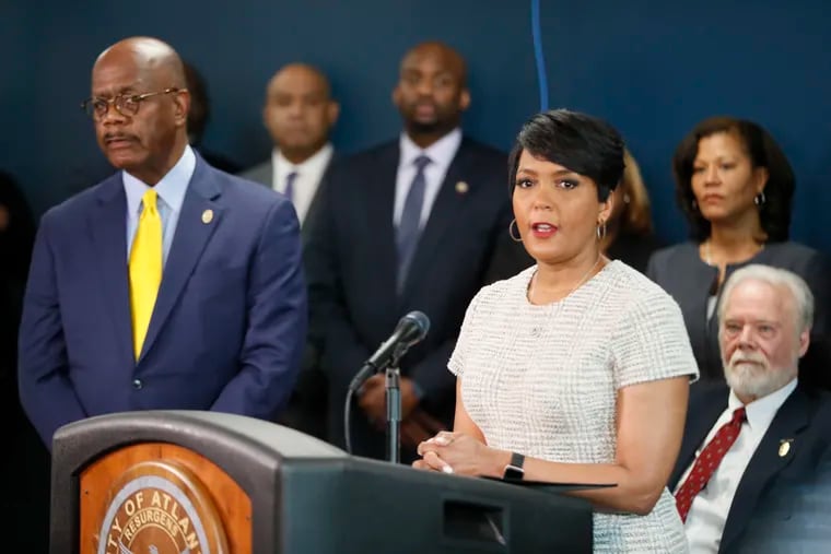 This March 2019 photo shows Atlanta Mayor Keisha Lance Bottoms (podium), standing next to Fulton County District Attorney Paul Howard.