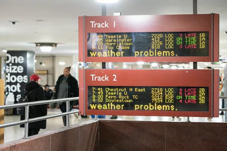 The train board reflects weather related delays Friday morning at Suburban Station, in Philadelphia.