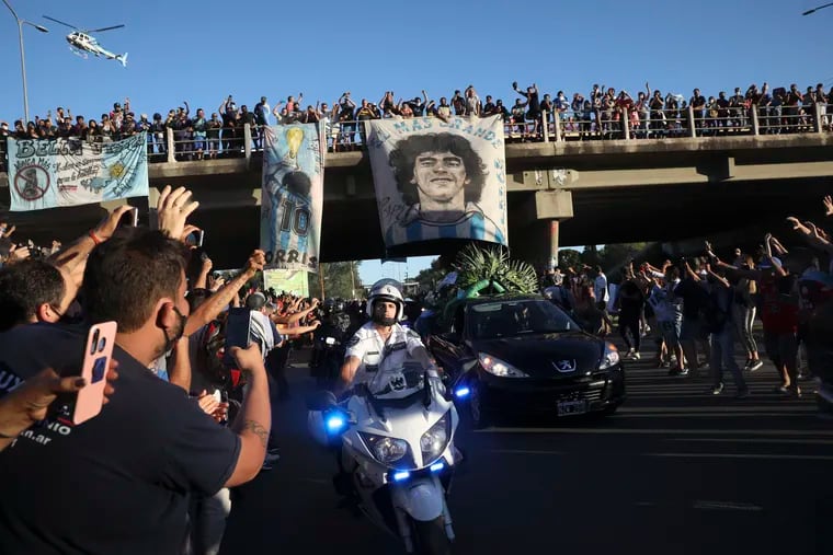 Mourning fans waved from an overpass at the caravan carrying the remains of Diego Maradona to his resting place in Buenos Aires, Argentina, on Thursday.