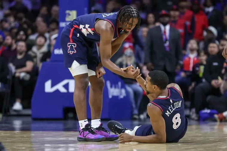 Injured Sixers guard De'Anthony Melton is helped up by teammate Tyrese Maxey in the second quarter Wednesday.