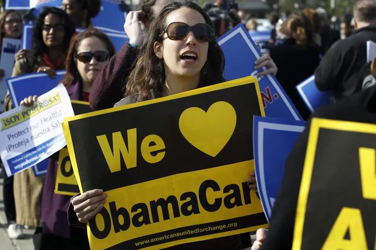 Supporters of the Affordable Care Act  stood in front of the Supreme Court in Washington on Wednesday, the final day of arguments regarding the health-care law signed by President Obama. The justices are reviewing the constitutionality of the 2,700-page law.  CHARLES DHARAPAK / Associated Press