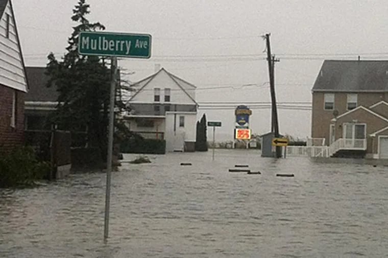 The flood waters were about a foot deep here in Wildwood a little earlier this morning. A "Welcome to Wildwood" sign is in the distance. (Jason Nark/Staff)