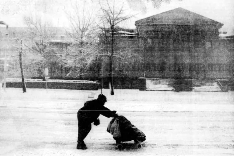 A woman pushes a stroller past the University of the Arts on an empty Broad Street following a blizzard that hit Philadelphia in 1993, the worst snow storm to hit the city in the month of March.