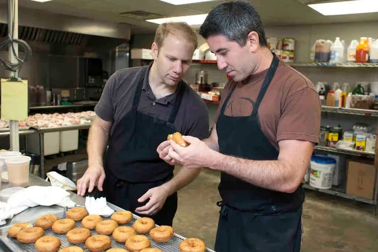 Owners Steve Cook (left) and Michael Solomonov check the consistency of a batch of lime custard-filled doughnuts for Federal Donuts.