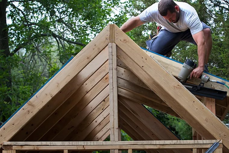 Justin Metzler, a contractor by trade, provided his driveway for the construction of the expertly framed tiny house. He is determined to make the house structurally sound and beautiful so there is no protest from towns over its design. LAURENCE KESTERSON / For The Inquirer